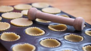 A cupcake tray filled with pastry cases