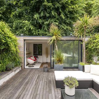 garden room with trees and wooden flooring