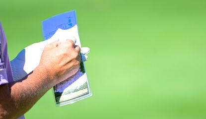 A players signs a scorecard at a LIV Golf event