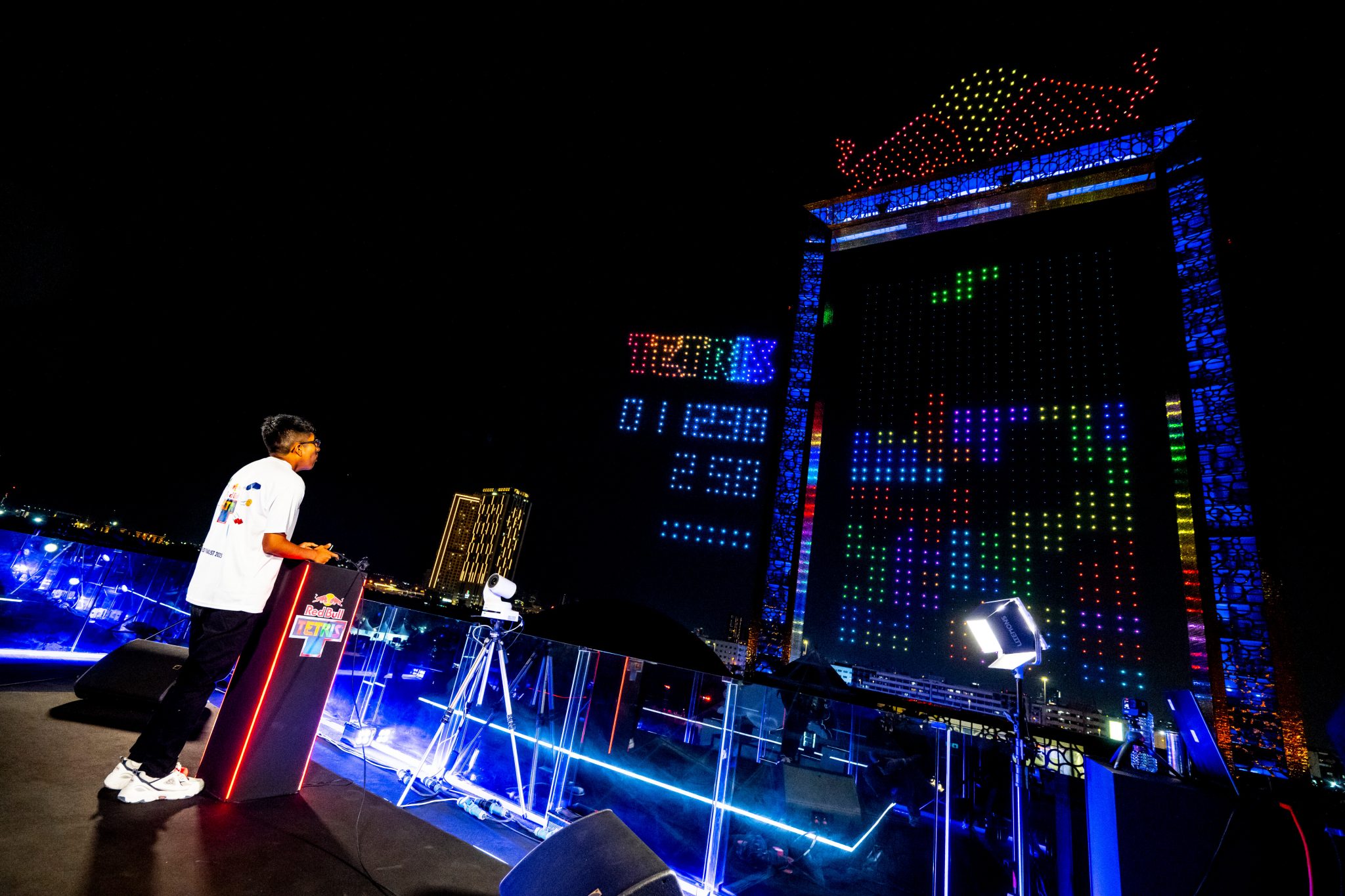 A young man plays Tetris on a massive immersive display.