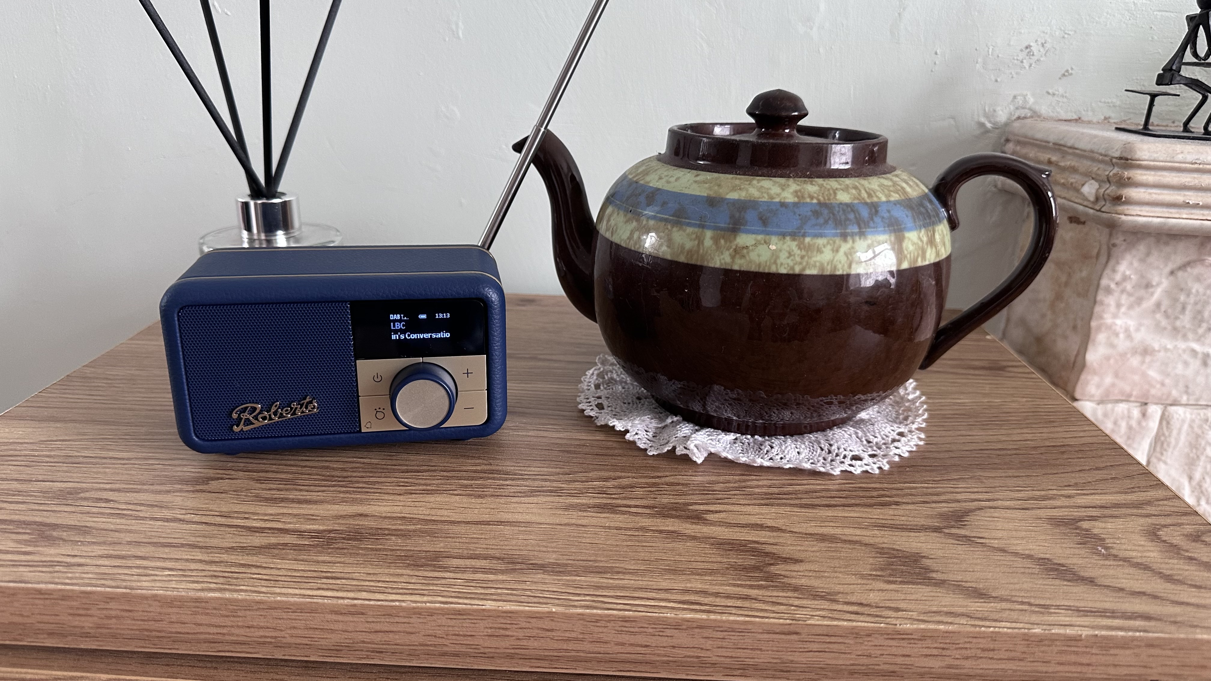 Roberts Revival Petite 2 with a teapot and reed diffuser, to show the size of this tiny radio