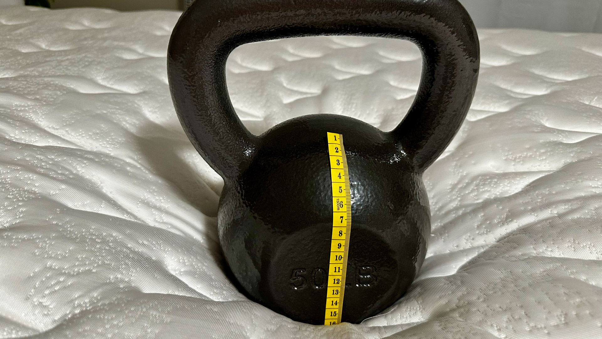 A kettlebell on the Glacier Apex Hybrid mattress