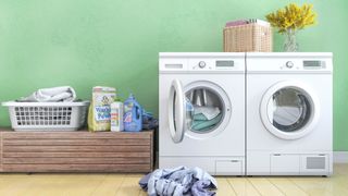 A washer and dryer next to each other, with laundry and detergent