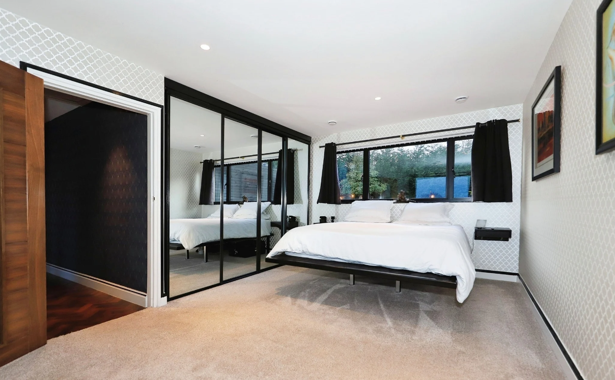 A freestanding bed and fitted wardrobes