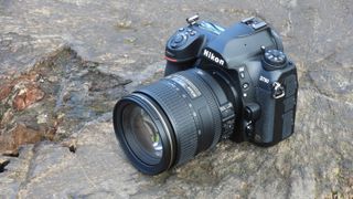 Nikon D780 står på en stor, grå sten i naturen