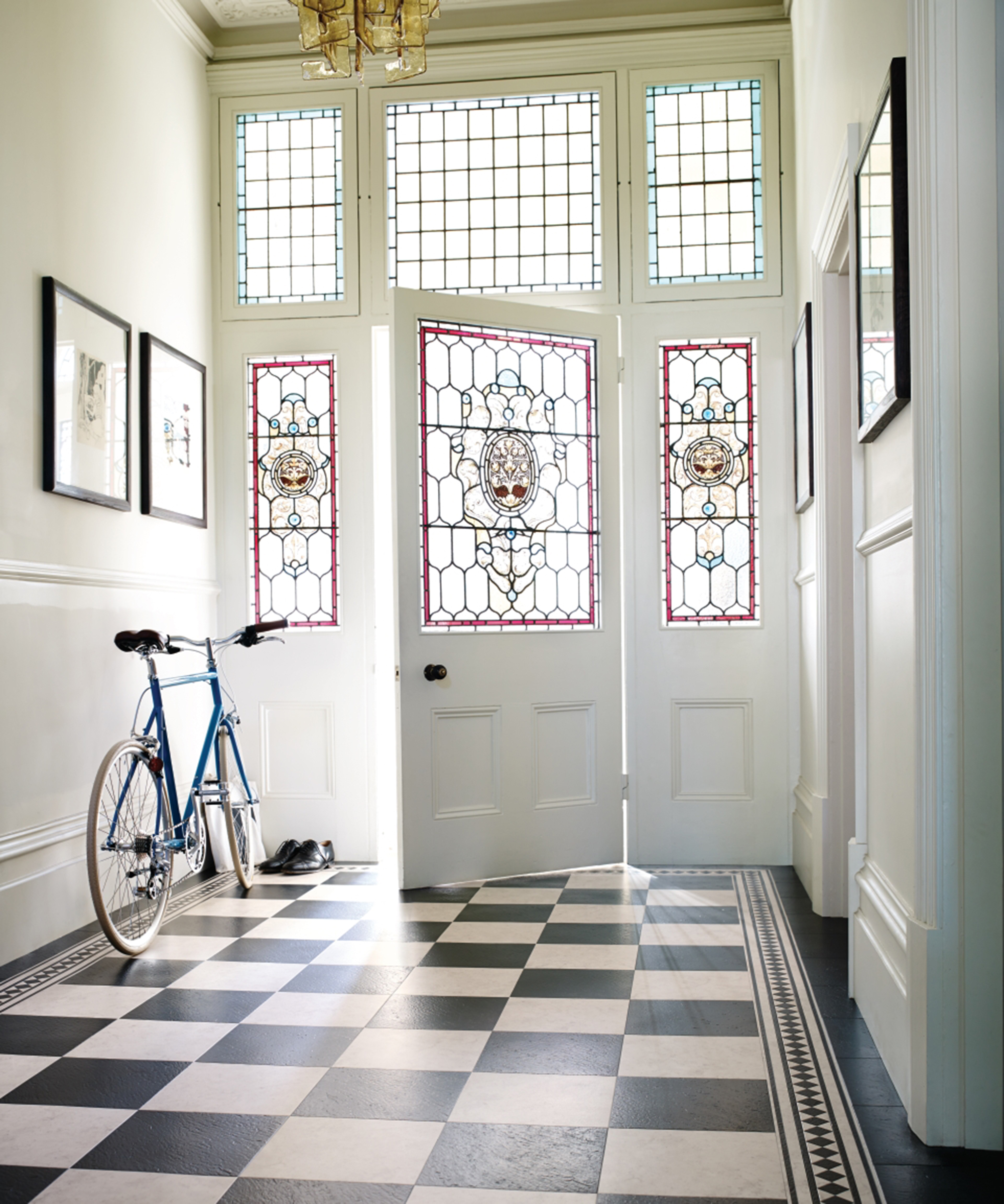 Hallway ideas by Amtico - Checkerboard flooring with stain glassed window doors and bicycle