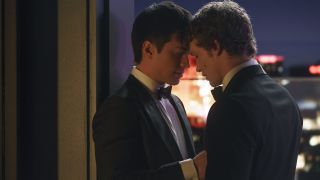 Shane (Hudson Williams) and Ilya (Connor Storrie), dressed in bow ties and tuxedos, share a private moment together in a hotel suite.