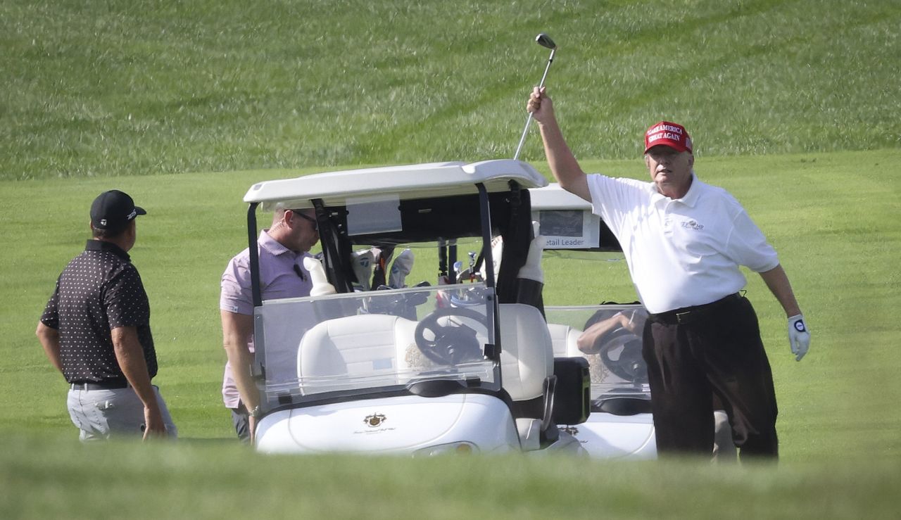 Trump gets a golf club out from his bag