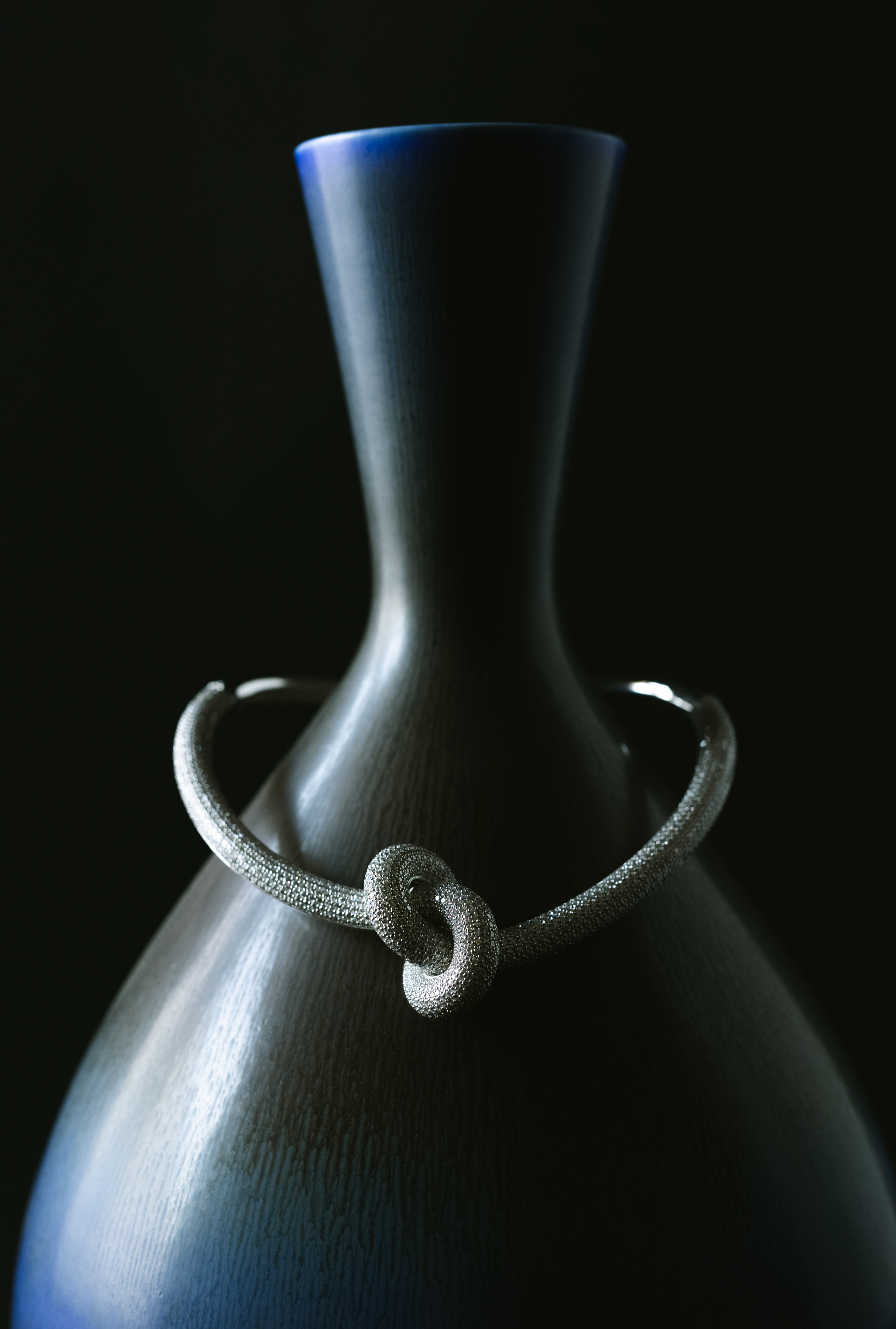 ceramics and jewellery against green and brown backgrounds