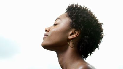 Young woman, eyes closed, low angle view, profile - stock photo