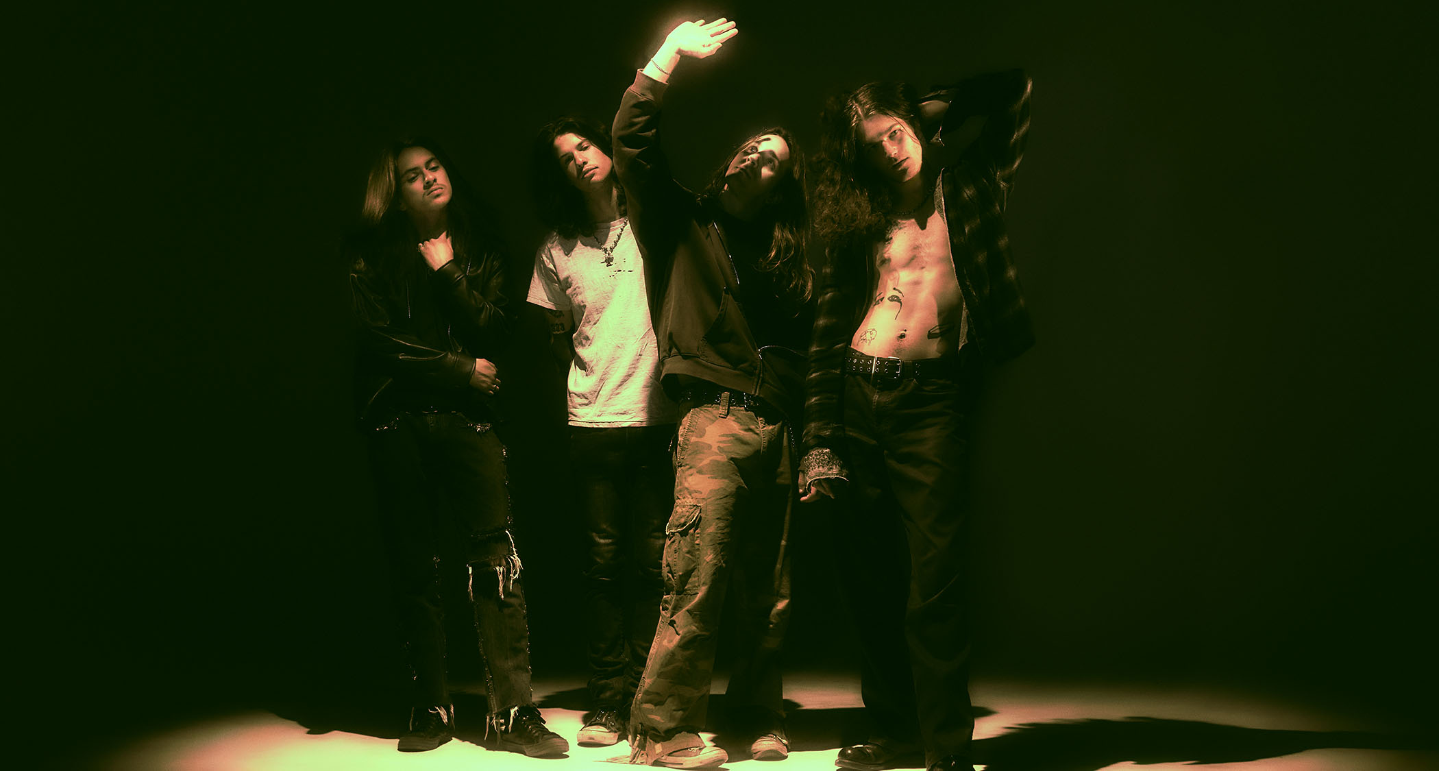 Return to Dust are pictured in a spotlight in a darkened room.