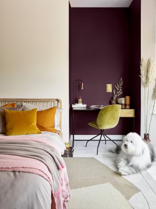 jewel toned bedroom with desk in aubergine painted alcove, and mustard pop cushions on bed.