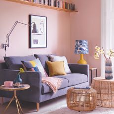 Pink living room with grey sofa and wicker coffee tables