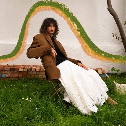 An image of a model wearing a blazer, jumper and full skirt for an autumn winter trend fashion story