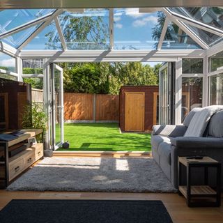 Interior of conservatory with sofa and couch, underneath glass dome roof