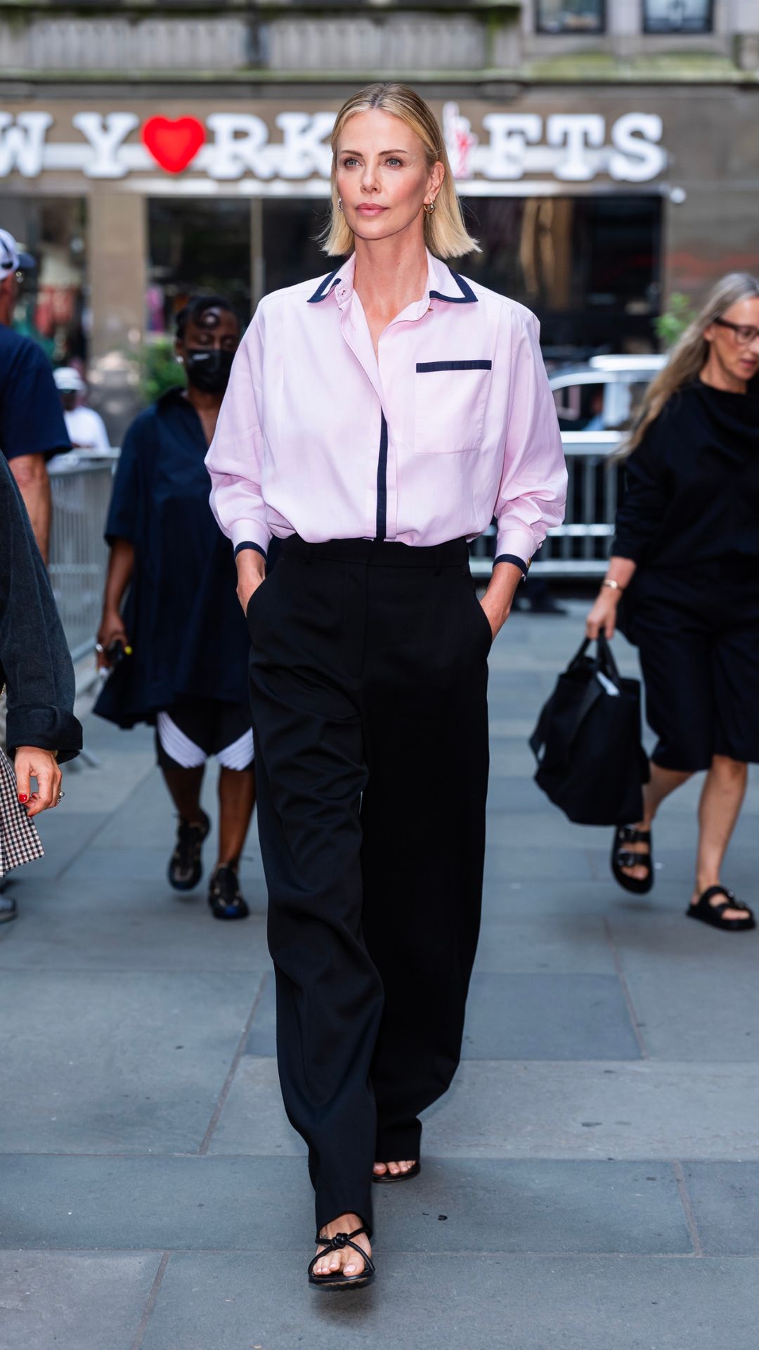 charlize theron wearing a pink shirt and trosuers