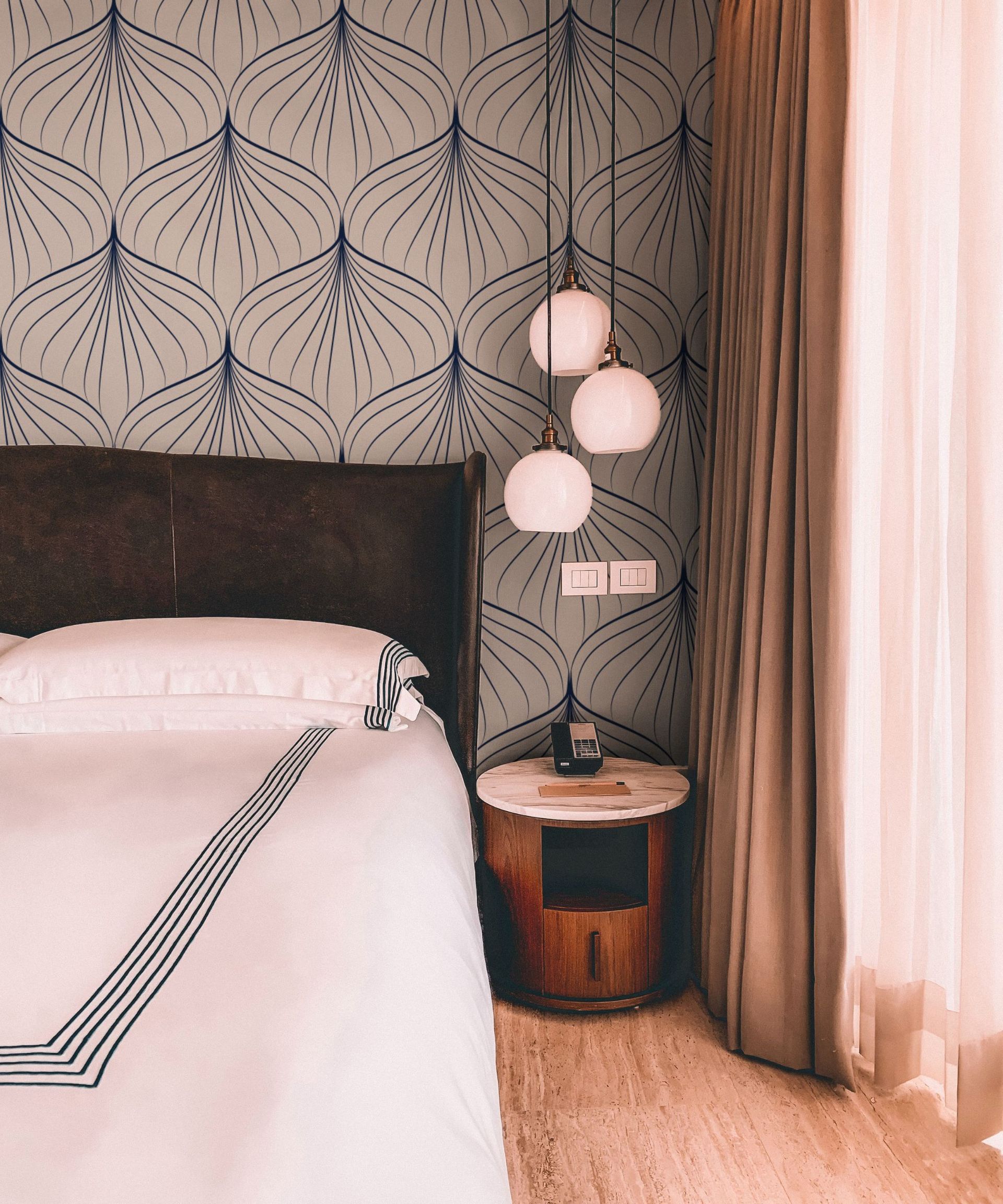 A pink bedroom with art deco details, including a sculptural light fixture