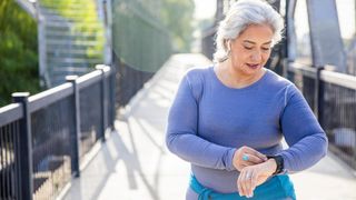 A woman looks at her watch while working out