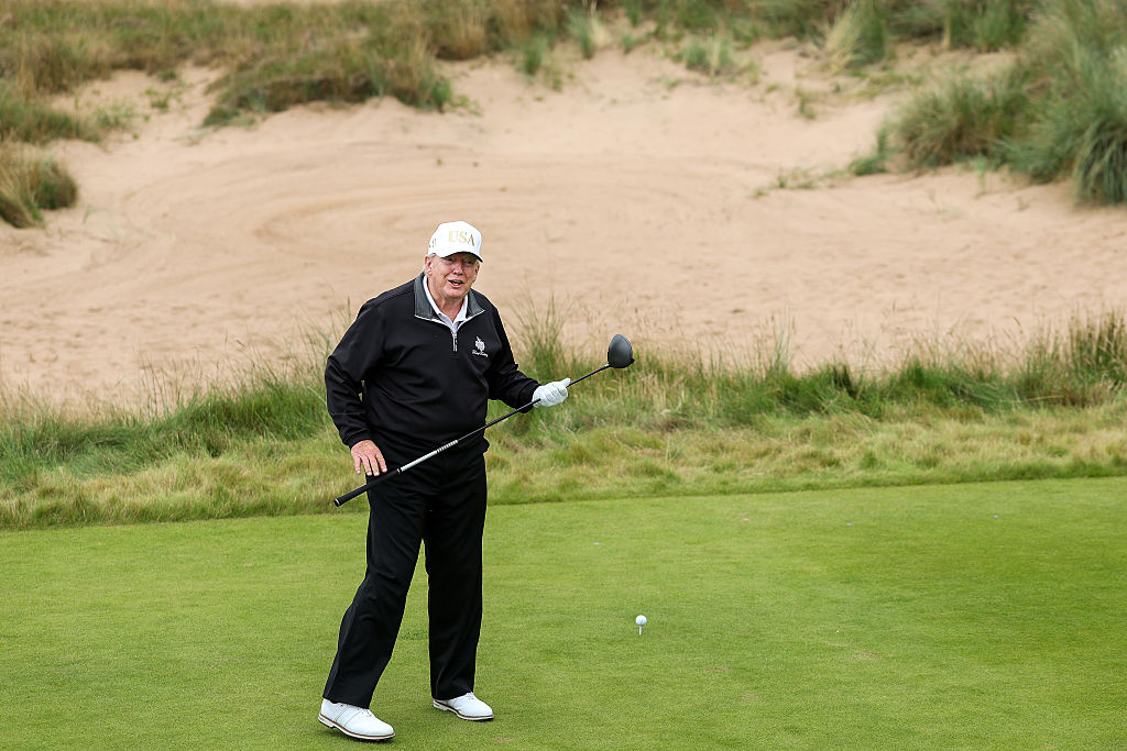 U.S. President Donald Trump holding a golf club. (Photo by Jeff J Mitchell/Getty Images)