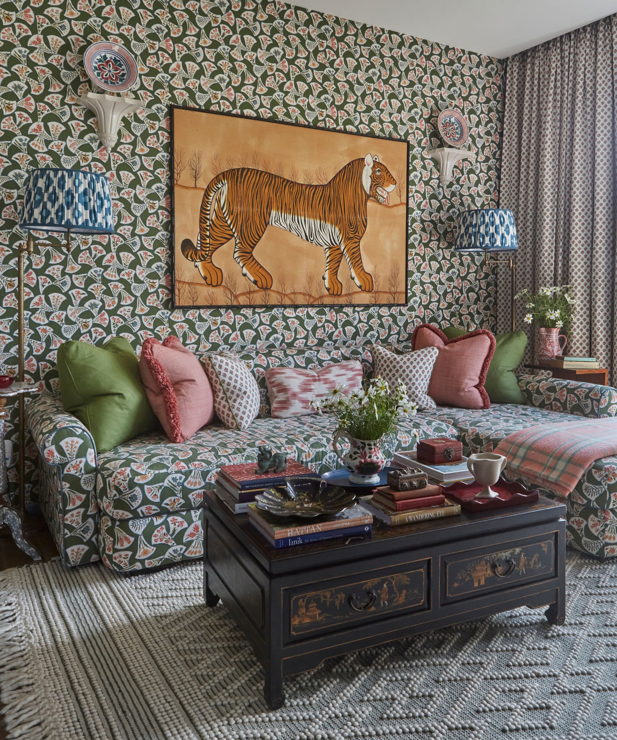 a patterned drenched snug room with matching printed wallpaper and L shaped couch, vintage coffee table and a large tiger print