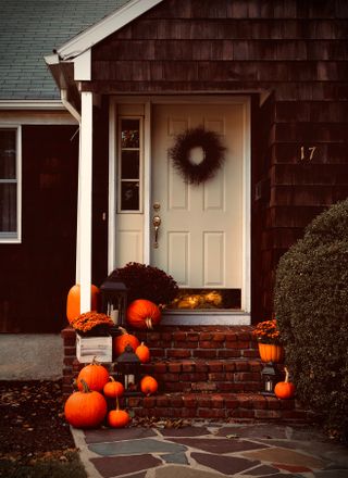 Front porch decorated for fall with pumpkins