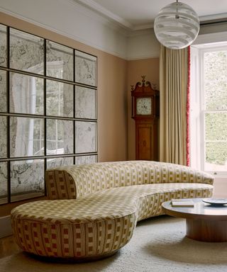 Sitting room in a townhouse with a contemporary sofa and a wall covered with framed maps of London