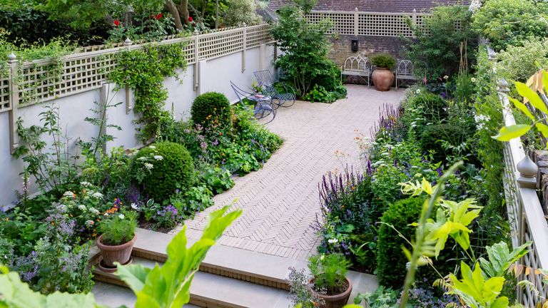 small and narrow garden design with herringbone paving, trellis and raised beds by Butter Wakefield Garden Design