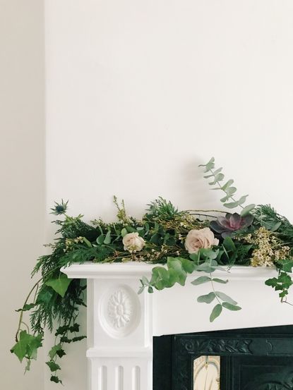 Christmas garland made from foraged pine, fir, eucalyptus, thistle and ivy placed on a mantle