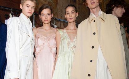 Models wear white trench coat, baby pink dress, light green dress, and beige trench coat 