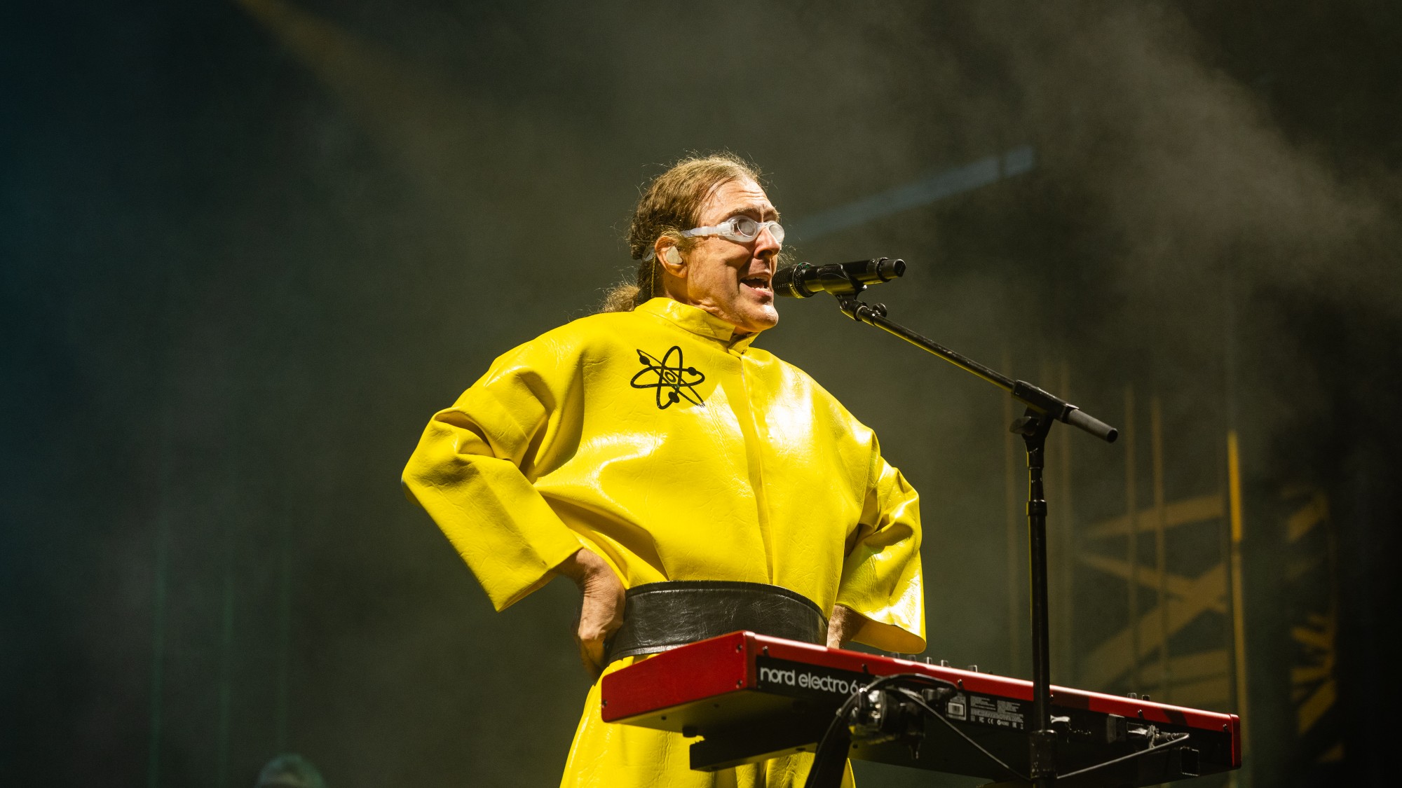 a man with curly, long hair sings into a microphone
