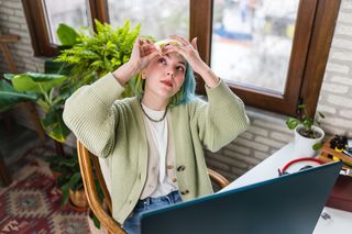 How to protect your eyes as a digital artist; a woman at desk putting in eye drops