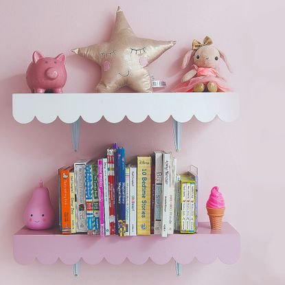 Two shelves in a kid's room with a scalloped trim