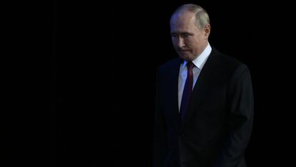 President Vladimir Putin enters a dark hall 