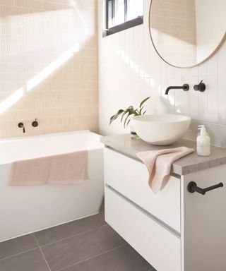 A tiled bathroom in light pink and white