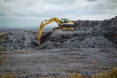 Excavator at waste dump at the site of the former Brymbo steel works near Wrexham