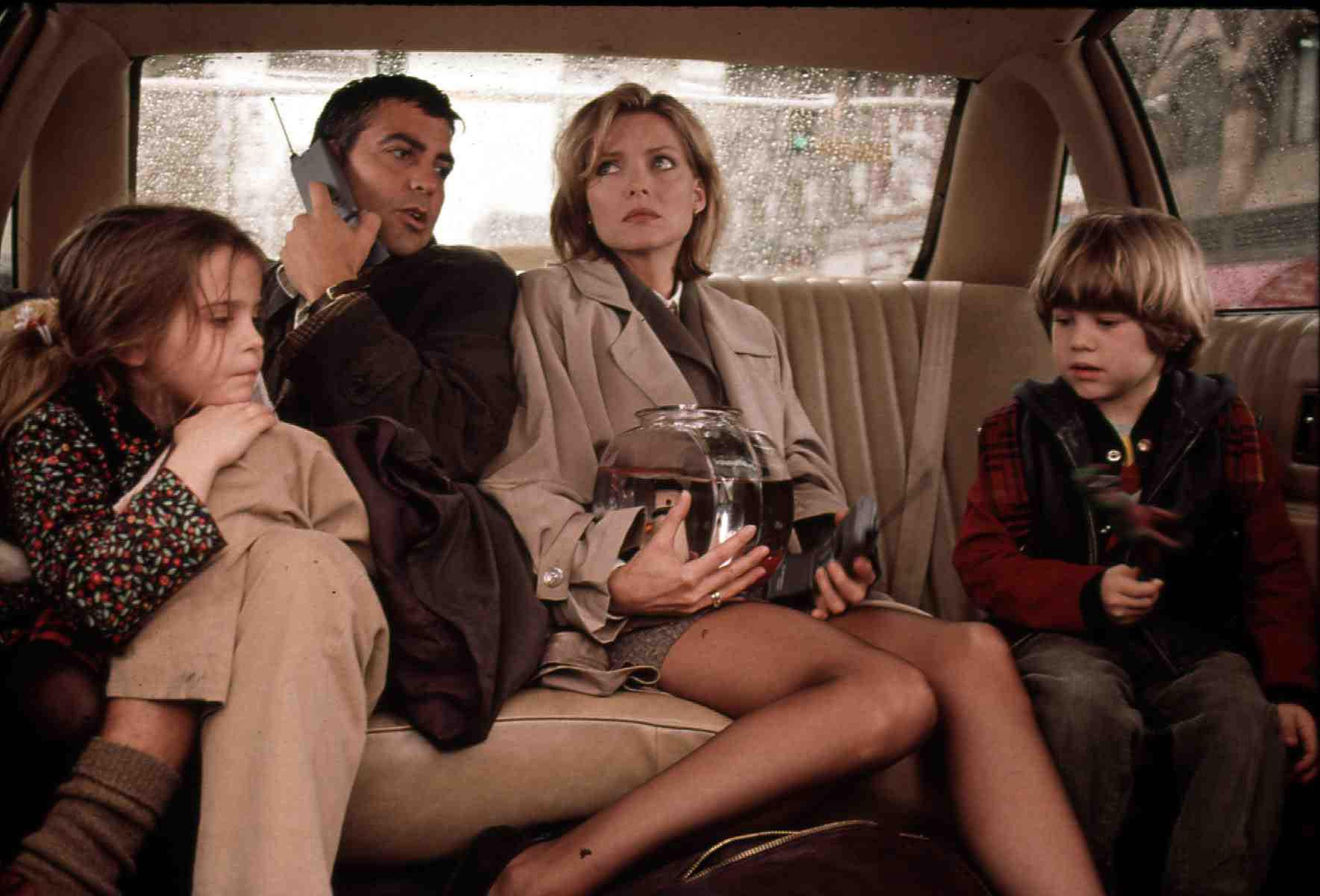 George Clooney and Michelle Pfeiffer in the back of a car with children in 'One Fine Day'