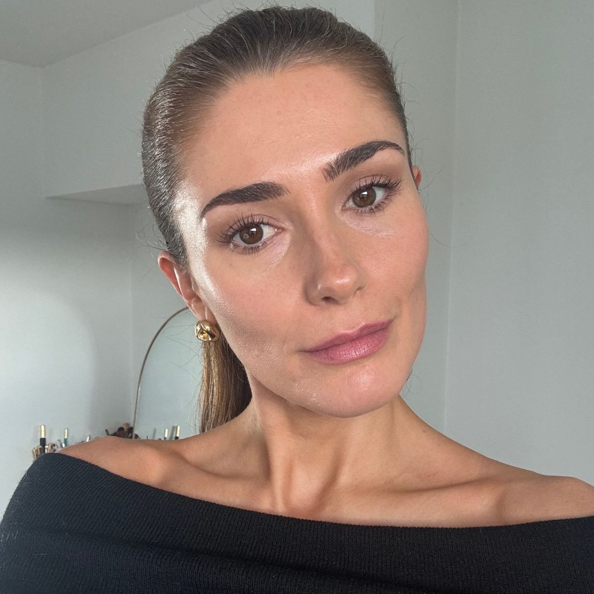 A collage with photos of the Ilia limitless mascara tube and wand, and a selfie of beauty editor Eleanor wearing the mascara on her lashes