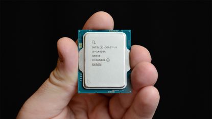 A hand holding an Intel Core i9-14900K