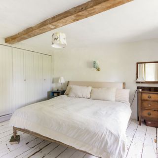 bedroom with wooden flooring and white walls