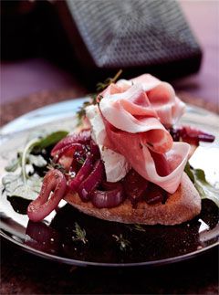 Parma ham and goats cheese toasts with cranberry and red onion