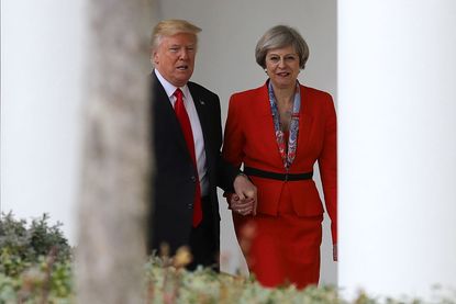 President Trump and Prime Minister Theresa May hold hands. 
