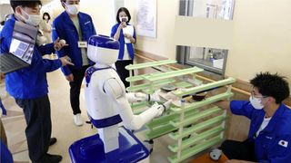 A D1 wheeled humanoid robot carries dishes on a tray during a trial at Juko Osu Hospital in Nagoya. 