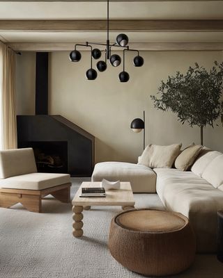 A living room with beige walls, beige seaters and black lights