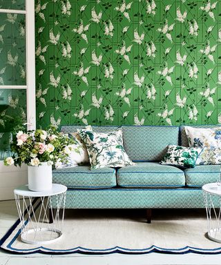 A green patterned wallpaper in a living room picture with blue patterned sofa.