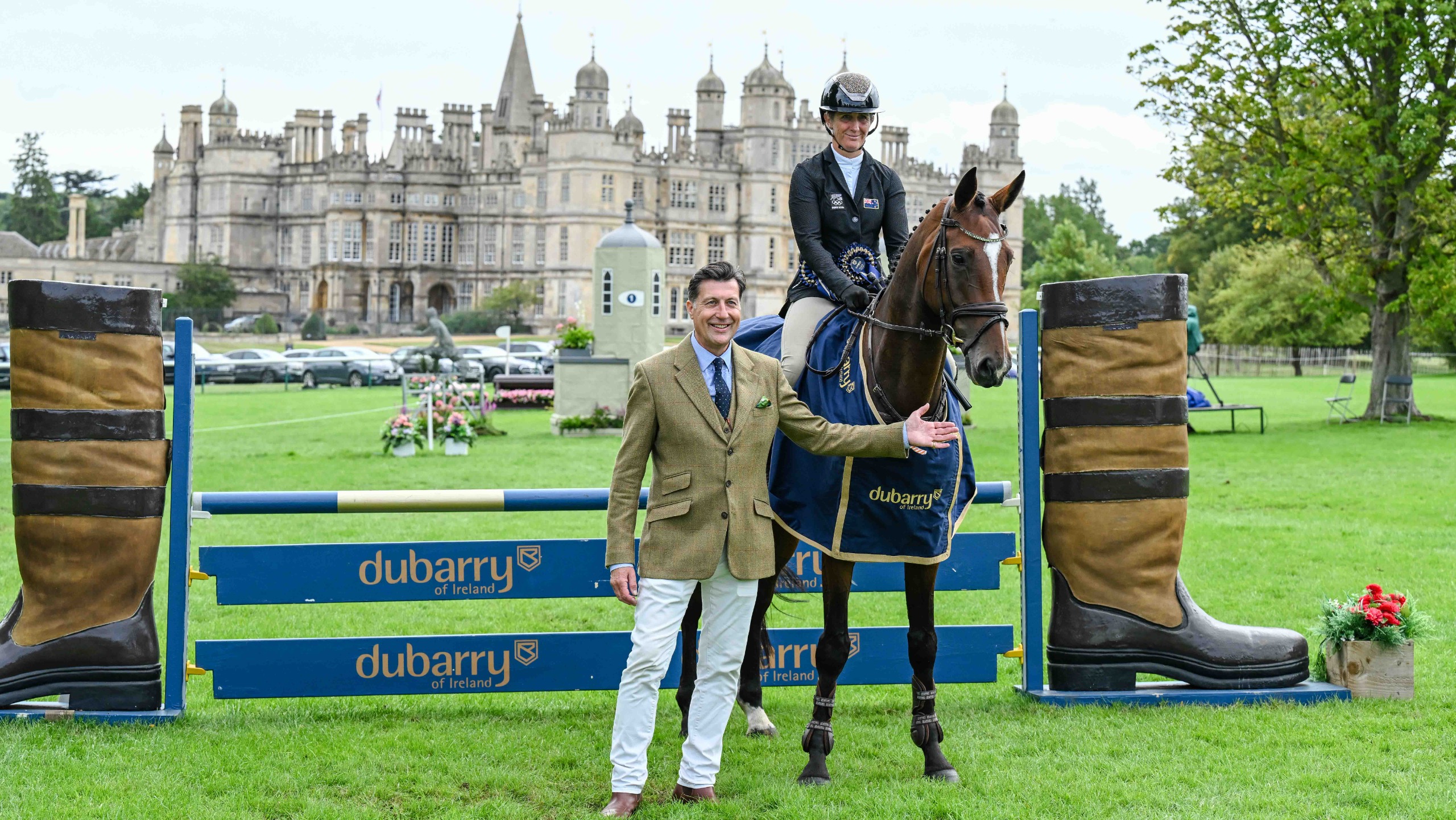 Caroline Powell sits on her winning mare, WLS Cula Bula, in her Dubarry-branded winners rug in front of Burghley House