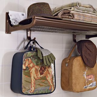 a vintage train carriage luggage rack on a wall with hat, gloves and blanket
