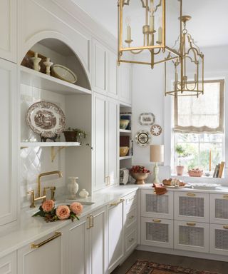 pantry with white cabinets and arched alcove