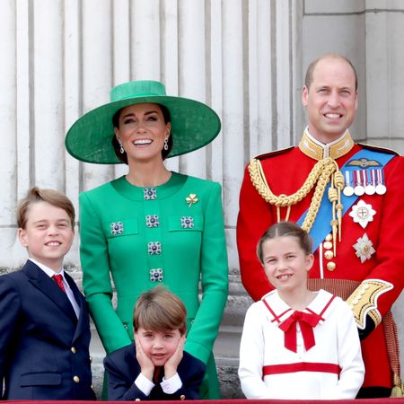 Princess Kate wears a green hat and matching outfit and stands on the Buckingham Palace balcony with Prince George, Princess Charlotte, Prince Louis, and Prince William