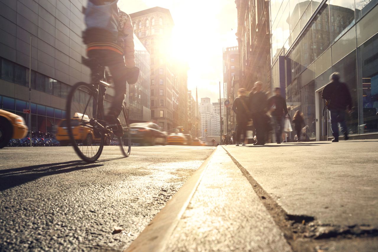 Image shows a rider not riding too close to the curb while cycle commuting to work.