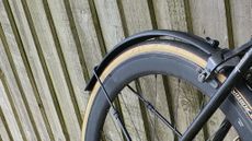 A close up of a mudguard attached to a rear wheel on a bicycle